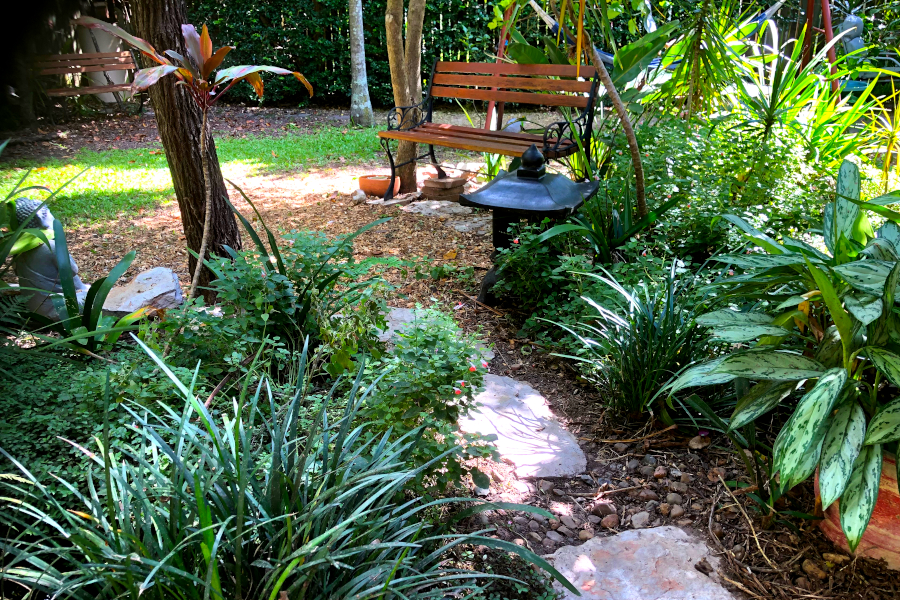 image of stone pavers through a peaceful garden leading to a garden seat